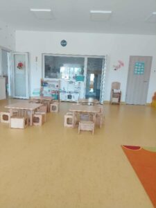 Katica bölcsis csoport terme. Asztalok és székek a teremben.